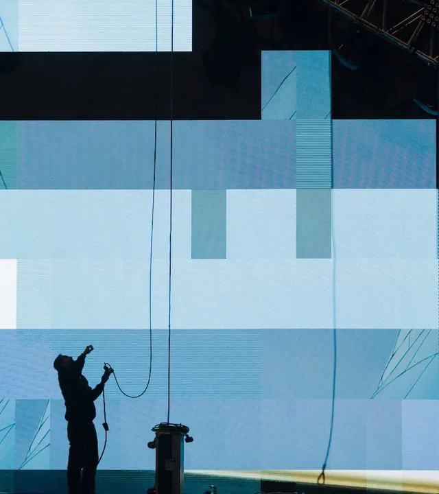Technician rigging a large LED video wall for a live event