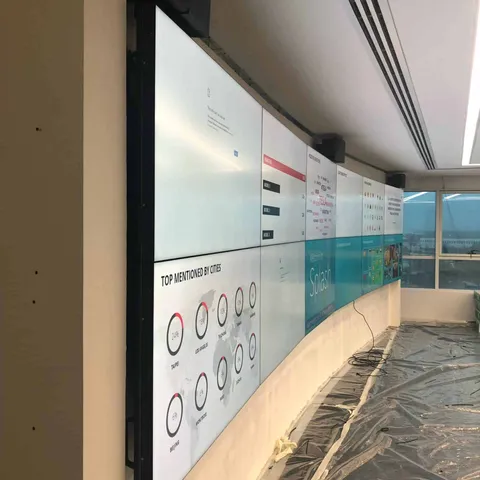 Long curved run of videowall screens along an office wall