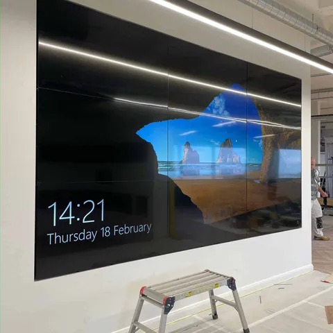 Large display flush-mounted into a white feature wall in a new office