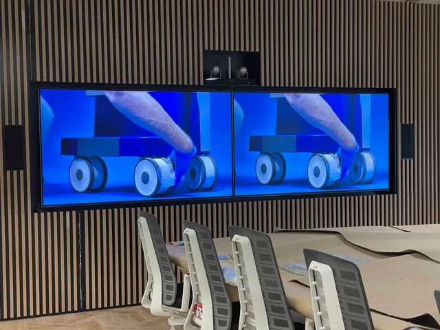 Boardroom with twin large-format displays and a central conferencing camera