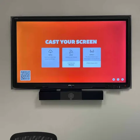 Wall-mounted display with soundbar showing a screen-casting menu