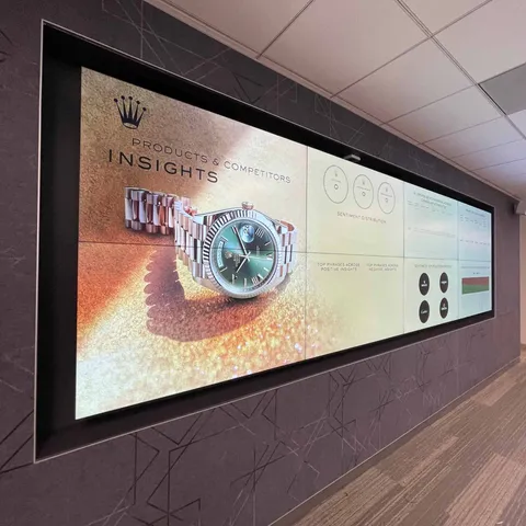 Wide LED display wall in a corridor showing a watch advert