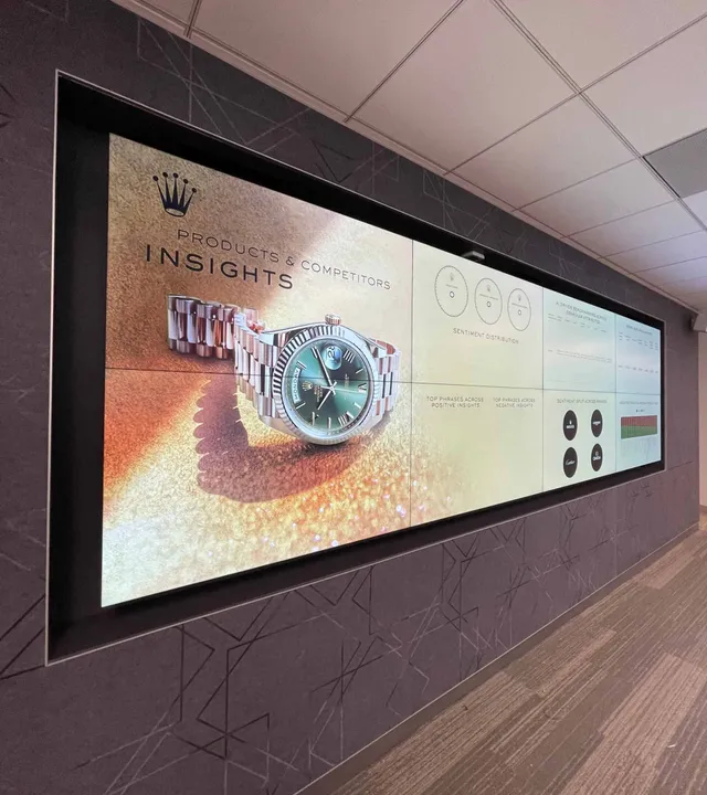 Wide LED display wall installed in a corridor showing a watch advert