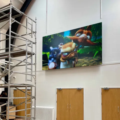 Large display showing a video game character mounted high on a venue wall
