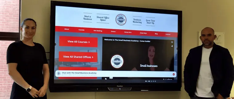 The Small Business Academy team beside their new Promethean ActivPanel in the training room